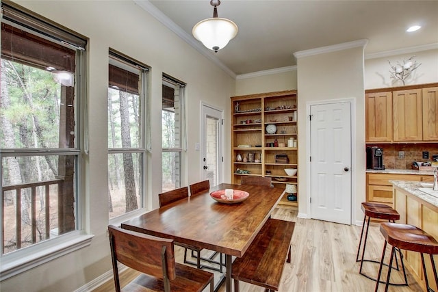 dining area featuring crown molding and light wood-type flooring