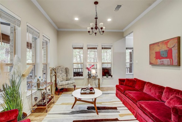 living room with ornamental molding, a notable chandelier, and light wood-type flooring