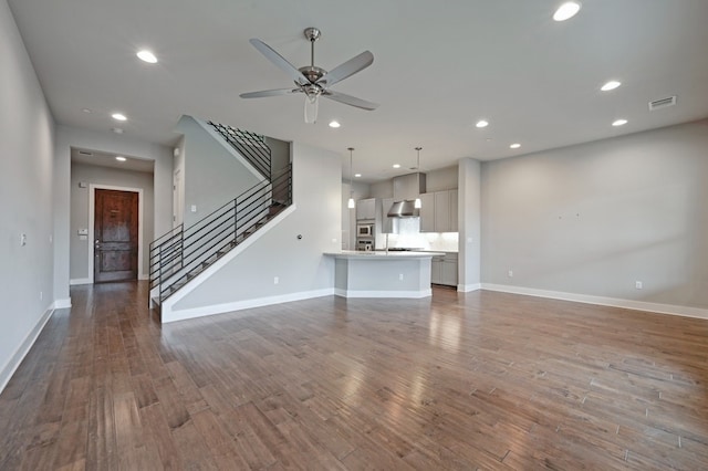 unfurnished living room with hardwood / wood-style floors and ceiling fan