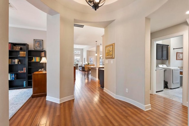 hall with dark wood-type flooring and independent washer and dryer