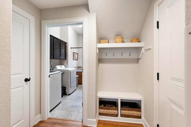 mudroom with washer and dryer and light wood-type flooring