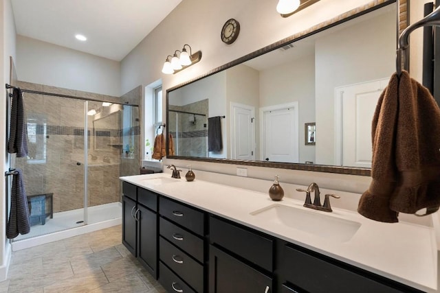 bathroom with a shower with door and vanity