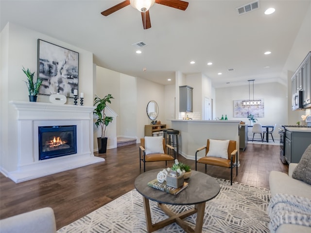 living room with dark hardwood / wood-style flooring, vaulted ceiling, and ceiling fan