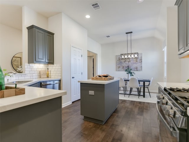 kitchen featuring sink, gray cabinets, appliances with stainless steel finishes, hanging light fixtures, and a kitchen island