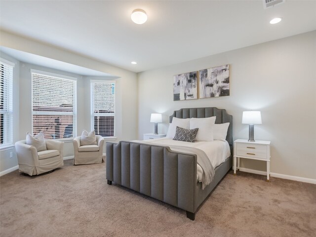 bedroom with multiple windows and light colored carpet