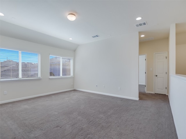 carpeted empty room with vaulted ceiling