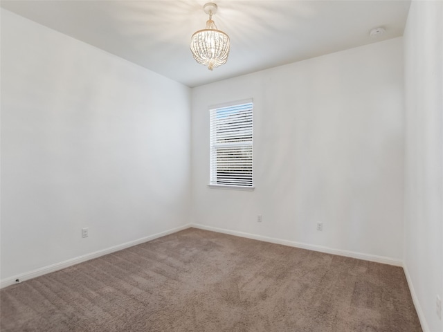 unfurnished room featuring carpet and a chandelier