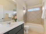 full bathroom featuring tiled shower / bath combo, vanity, tile patterned flooring, and toilet