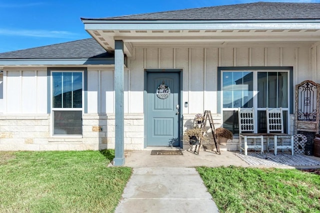 entrance to property with a yard and covered porch