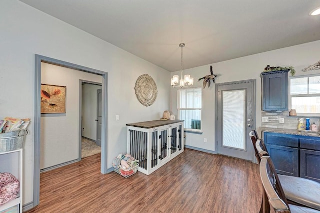 kitchen featuring wood-type flooring, a wealth of natural light, pendant lighting, and decorative backsplash