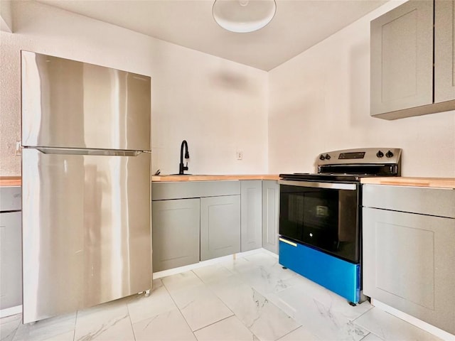 kitchen with appliances with stainless steel finishes, gray cabinets, and sink