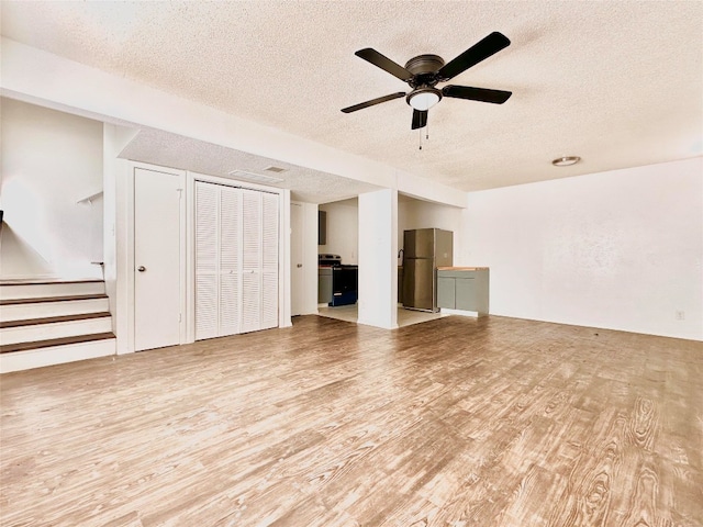 unfurnished living room with ceiling fan, wood-type flooring, and a textured ceiling