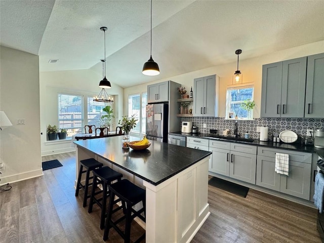 853 Cypress Ln, Cottonwood Shores, TX 78657 - kitchen with appliances with stainless steel finishes, dark countertops, a sink, dark wood finished floors, and a textured ceiling
