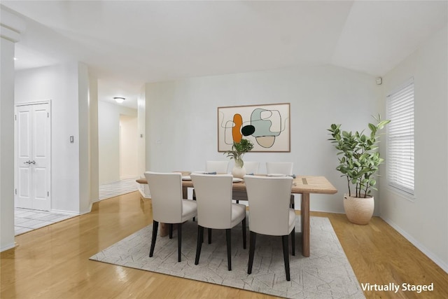 dining space with lofted ceiling and light hardwood / wood-style floors