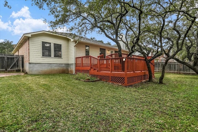 rear view of property featuring a wooden deck and a yard