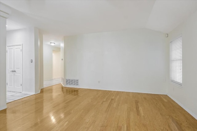 unfurnished room with vaulted ceiling and light hardwood / wood-style floors