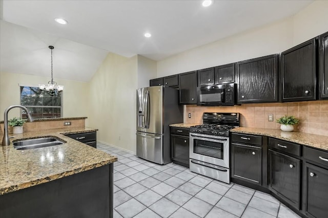 kitchen with decorative light fixtures, lofted ceiling, sink, backsplash, and stainless steel appliances