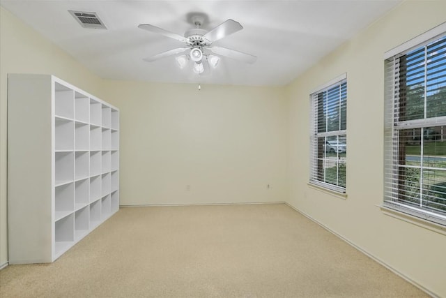 carpeted spare room with ceiling fan