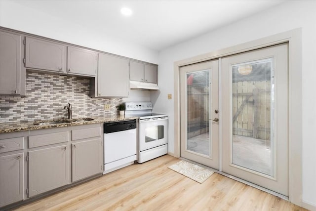 kitchen with gray cabinets, tasteful backsplash, sink, light wood-type flooring, and white appliances