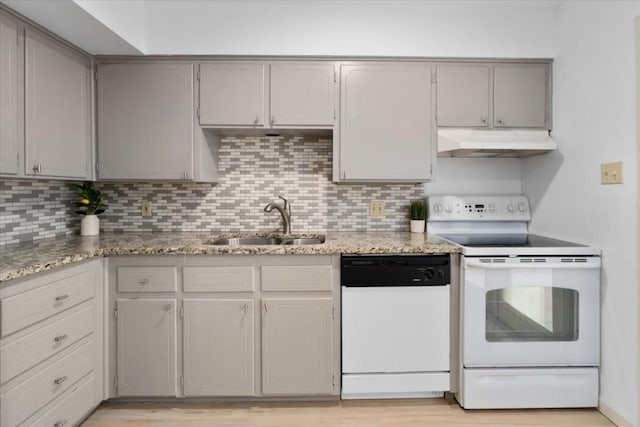 kitchen with tasteful backsplash, sink, gray cabinetry, and white appliances