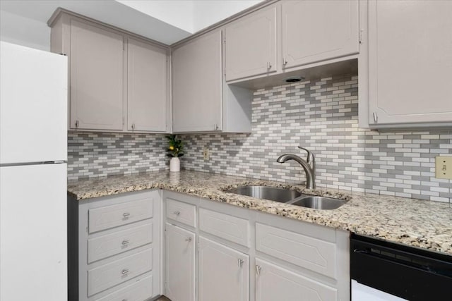 kitchen with white refrigerator, dishwasher, sink, and white cabinetry