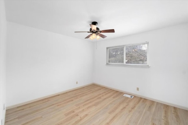 spare room with ceiling fan and light wood-type flooring