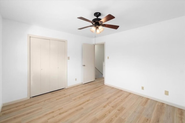 unfurnished bedroom with ceiling fan, light hardwood / wood-style floors, and a closet