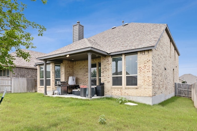 rear view of house with a yard and a patio area