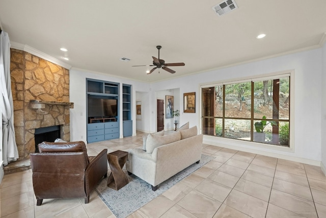 living room featuring a stone fireplace, ornamental molding, ceiling fan, and light tile patterned flooring