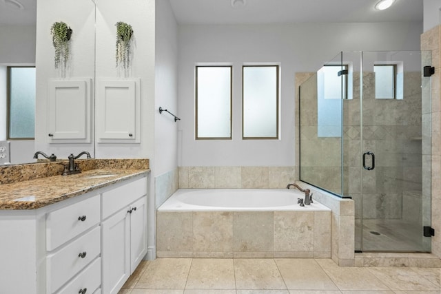 bathroom with tile patterned floors, vanity, and shower with separate bathtub