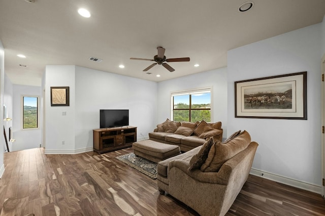 living room featuring dark wood-type flooring and ceiling fan