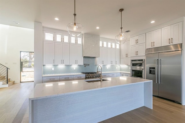 kitchen with pendant lighting, sink, white cabinets, and appliances with stainless steel finishes