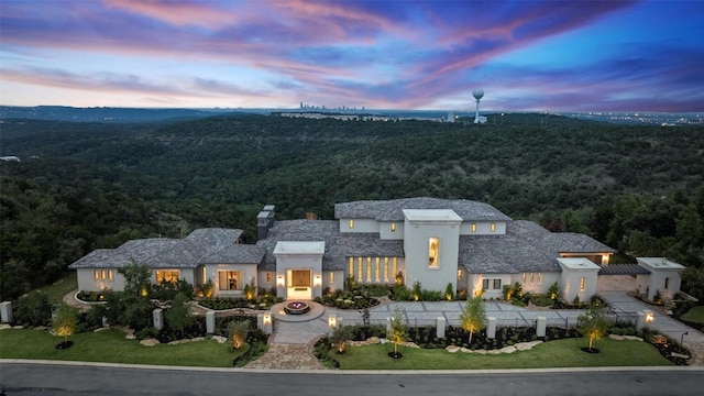 4901 Mirador Dr, Austin, TX 78735 - view of front of house featuring a wooded view, stucco siding, and curved driveway