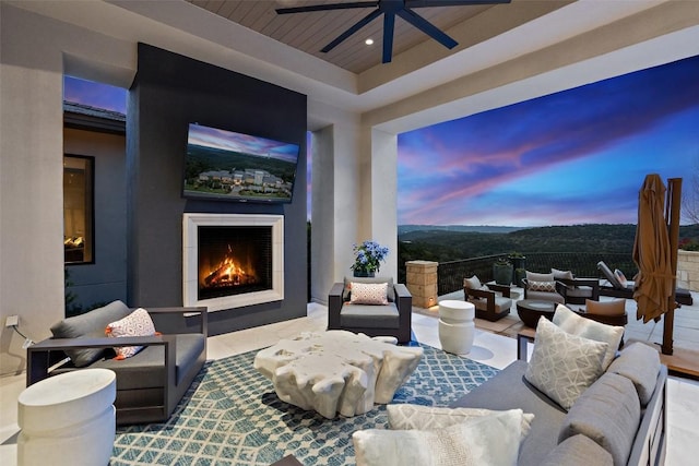 interior space with ceiling fan and exterior fireplace