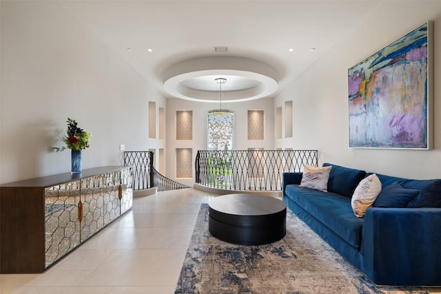 interior space with light tile patterned flooring and a tray ceiling