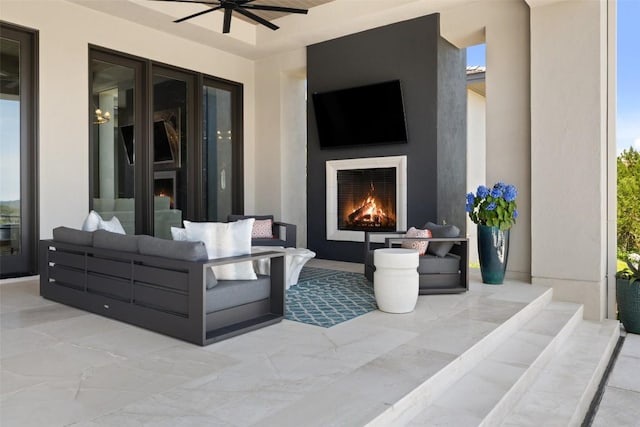 view of patio / terrace with an outdoor living space with a fireplace and a ceiling fan