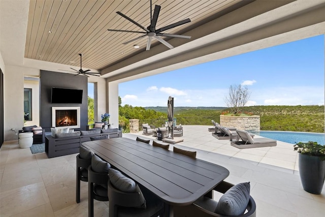 view of patio featuring an outdoor pool, outdoor dining area, and an outdoor living space with a fireplace