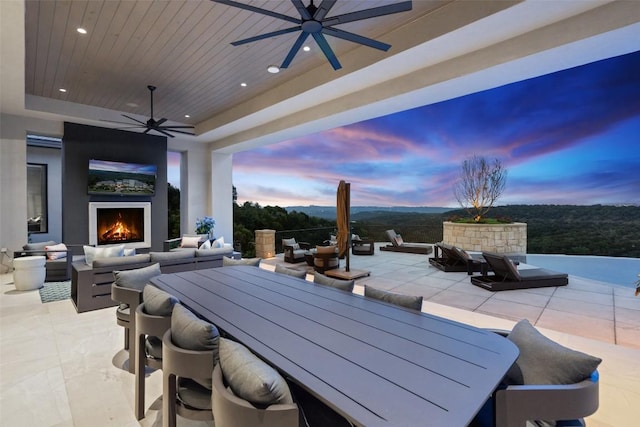 4901 Mirador Dr, Austin, TX 78735 - patio terrace at dusk featuring outdoor dining space, ceiling fan, a patio area, and an outdoor living space with a fireplace