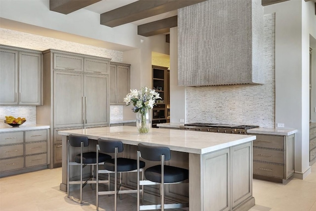 4901 Mirador Dr, Austin, TX 78735 - kitchen featuring tasteful backsplash, gray cabinetry, a kitchen island, stainless steel gas stovetop, and beam ceiling