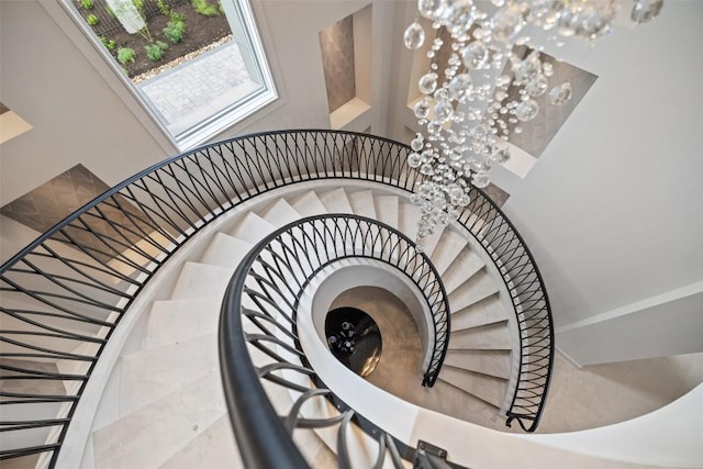 stairs with a towering ceiling and a chandelier