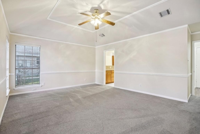 carpeted empty room featuring crown molding, vaulted ceiling, and ceiling fan