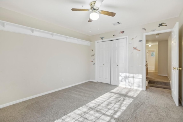 unfurnished bedroom featuring light carpet, ceiling fan, and a closet