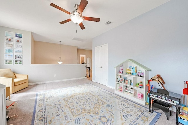 playroom with ceiling fan and carpet