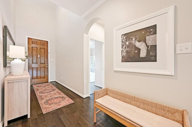 foyer with ornamental molding and dark hardwood / wood-style floors