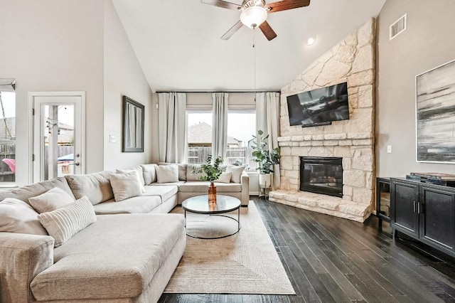 living room featuring ceiling fan, a fireplace, dark hardwood / wood-style floors, and high vaulted ceiling