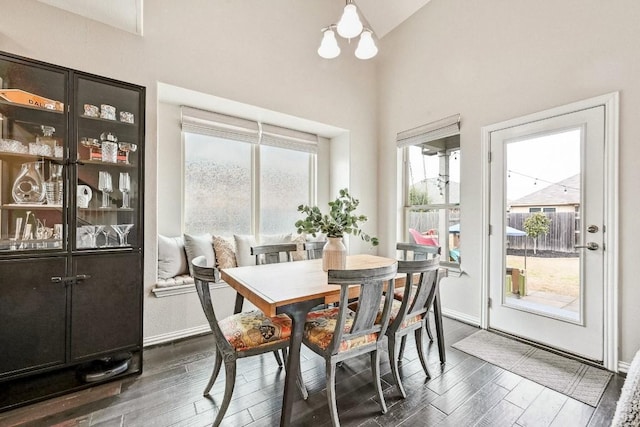 dining room featuring dark hardwood / wood-style flooring, lofted ceiling, and a chandelier