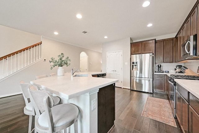 kitchen featuring appliances with stainless steel finishes, a breakfast bar area, sink, and a center island with sink