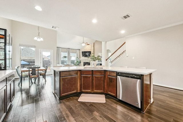 kitchen featuring pendant lighting, dark hardwood / wood-style flooring, stainless steel dishwasher, and a center island with sink