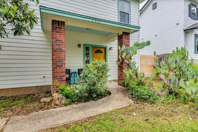 view of exterior entry featuring covered porch