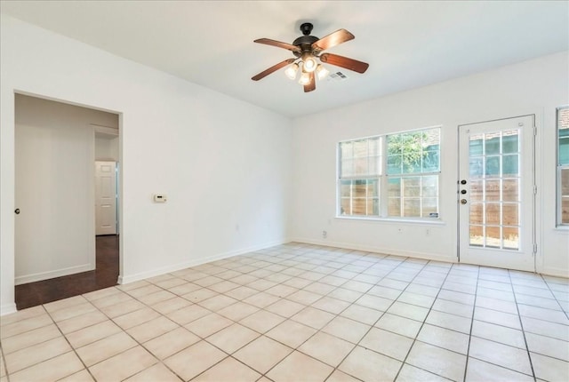 tiled spare room with ceiling fan